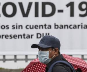 A man wears a face mask against the spread of the new coronavirus (COVID-19) as he waits to enter a bank to receive a $300 USD bonus -granted by the government for vulnerable people- in Santa Tecla, El Salvador on April 3, 2020. - Latin America is heading into 'a deep recession' in 2020, with an expected drop in the region's GDP of 1.8 to 4.0 percent due to the coronavirus pandemic, the UN economic commission for the region said Friday. (Photo by Yuri CORTEZ / AFP)