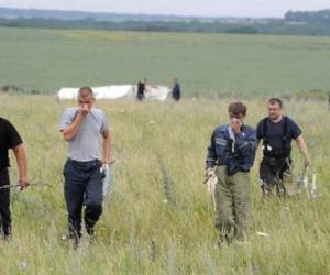 Varias personas buscan cuerpos en el lugar donde cayó el avión de Malaysian Airlines en Shaktarsk, en el este de Ucrania, el 18 de julio de 2014. (Foto: AFP)