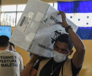 Trabajadores del Tribunal Supremo Electoral (TSE) mueven material para ser tabulado. AFP PHOTO / ORLANDO SIERRA