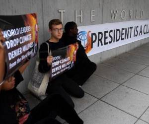 Los activistas exhiben una pancarta que llama al presidente del Banco Mundial, David Malpass, un “negador del clima”, frente a la sede del Banco Mundial en Washington, DC, el 22 de septiembre de 2022. - Los grupos climáticos pidieron que se destituyera a Malpass después de que se negara varias veces para decir si creía que las emisiones provocadas por el hombre contribuyeron al calentamiento global el 21 de septiembre. (Foto de OLIVIER DOULIERY / AFP)