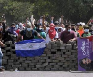 Students wait for riot police agents in a barricade close to Nicaragua's Technical College during protests against government's reforms in the Institute of Social Security (INSS) in Managua on April 21, 2018.Violent protests against a proposed change to Nicaragua's pension system have left at least 10 people dead over two days, the government said Friday. In the biggest protests in President Daniel Ortega's 11 years in office in this poor Central American country, people are angry over the plan because workers and employers would have to chip in more toward the retirement system. / AFP PHOTO / INTI OCON