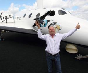 Sir Richard Branson stand by the Virgin Galactic Space craft at the Farnborough International Airshow on Nov. 7, 2012 in Hampshire. (Photo by Steve Parsons/PA Images via Getty Images)