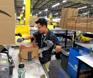 Amazon associate Swat Long, of Manteca, puts packing material into a box at the Amazon fulfillment center in Tracy, Calif., on Tuesday, April 12, 2016. (Doug Duran/Bay Area News Group)