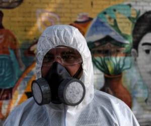 Un trabajador municipal participa en la desinfección de barrios para prevenir la propagación del coronavirus, COVID-19, en San Salvador (Foto de Yuri CORTEZ / AFP)