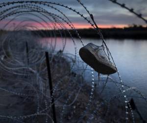 <i>El zapato de un niño cuelga atrapado en alambre de púas en la cima de la orilla del Río Grande el 9 de enero de 2024 en Eagle Pass, Texas. FOTO John Moore/Getty Images/AFP</i>