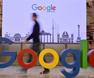 A technician passes by a logo of US internet search giant Google during the opening day of a new Berlin office of Google in Berlin on January 22, 2019. (Photo by Tobias SCHWARZ / AFP)