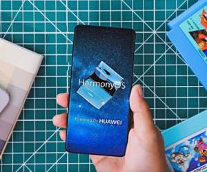 A guest holds her phone showing a picture taken during Huawei's press conference unveiling its new HarmonyOS operating system in Dongguan, Guangdong province on August 9, 2019. - Chinese telecom giant Huawei unveiled its own operating system on August 9, as it faces the threat of losing access to Android systems amid escalating US-China trade tensions. (Photo by FRED DUFOUR / AFP)