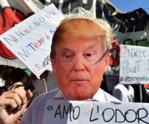 A demonstrator wearing a US president Donald Trump mask protests during a demonstration on the first day of a G7 summit of Environment on June 11, 2017. In Bologna. / AFP PHOTO / Alberto PIZZOLI