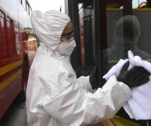 Desinfectan un bus en Colombia. Foto Raul ARBOLEDA / AFP)