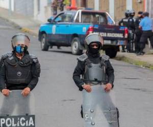 (ARCHIVOS) En esta foto de archivo tomada el 04 de agosto de 2022, policías y antidisturbios bloquean la entrada principal de la Curia Arzobispal de Matagalpa impidiendo la salida de Monseñor Rolando Álvarez, en Matagalpa, Nicaragua. - El obispo nicaragüense Rolando Álvarez, crítico con el gobierno de Daniel Ortega, fue sacado “violentamente” de su residencia en Matagalpa (norte), donde estuvo retenido por policías durante dos semanas, y se desconoce su paradero, dijo en agosto una organización de derechos humanos. 19 de febrero de 2022. (Foto de AFP)