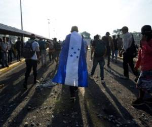 Honduran migrants remain on the international border bridge between Guatemala and Mexico in Ciudad Tecun Uman, Guatemala, where a security fence close to the border has been reinforced a day after Honduran migrants tried to cross into Mexico, on October 29, 2018. - A new group of Honduran migrants is trying to reach and cross the Guatemalan border into Mexico in the hope of eventually realizing the 'American dream' and reaching the United States. (Photo by Johan ORDONEZ / AFP)