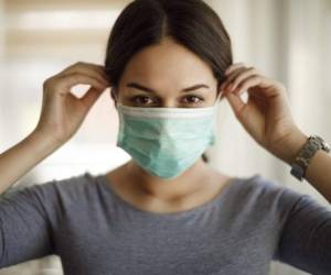 Portrait of young woman putting on a protective mask