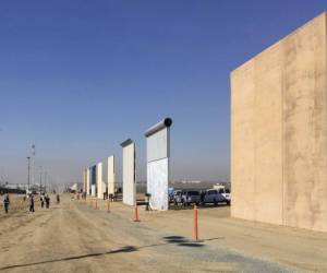 People look at prototypes of a border wall Thursday, Oct. 26, 2017, in San Diego. Contractors have completed eight prototypes of President Donald Trump's proposed border wall with Mexico, triggering a period of rigorous testing to determine if they can repel sledgehammers, torches, pickaxes and battery-operated tools. (AP Photo/Elliott Spagat)