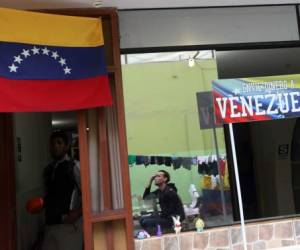 Venezuelan migrants stand next to a sign reading: ' Send money to Venezuela' at a shelter for Venezuelans in San Juan de Lurigancho, on the outskirts of Lima, Peru March 9, 2018. REUTERS/Mariana Bazo