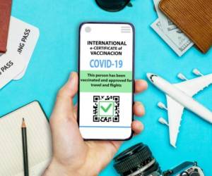 Coronavirus vaccination certificate or vaccine passport for travellers concept. COVID-19 immunity e-passport in the smartphone mobile app for international travelling. Blue background with toy plane