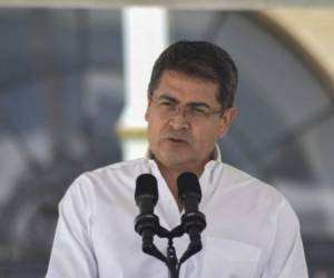 Honduran President Juan Orlando Hernandez speaks during a joint press conference with Guatemalan President Jimmy Morales (out of frame) at the Guatemalan Air Force base, near Guatemala City on October 20, 2018, before discussing the migration crisis and a possible 'safe return' plan. - Thousands of migrants who forced their way through Guatemala's northwestern border and flooded onto a bridge leading to Mexico, where riot police battled them back, on Saturday waited at the border in the hope of continuing their journey to the United States. (Photo by Orlando ESTRADA / AFP)