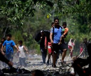 Grupos de personas migrantes caminan en la selva del Darién, para luego ser trasladados en canoa desde la Quebrada León hasta a la comunidad de Bajo Chiquito (Panamá). EFE/ Bienvenido Velasco