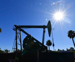 (FILES) In this file photo taken on October 21, 2019 a pumpjack from California-based energy company Signal Hill Petroleum is seen in front of the landmark Curley's Cafe, one of two pumpjacks in the Diner's parking lot which has been churning out oil from the ground below since 1921 in Signal Hill, California. - Global oil demand will fall by a record amount this year as lockdown measures imposed to curb the coronavirus outbreak bring the economy to a virtual halt, the International Energy Agency (IEA) said on April 15, 2020. (Photo by Frederic J. BROWN / AFP)