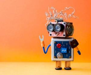Friendly crazy robot handyman on orange background. Creative design cyborg toy. Copy space photo.