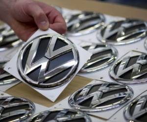 An employee passes by a Volkswagen ID. logo at the headquarters of German car maker Volkswagen in Wolfsburg on October 26, 2020. (Photo by Ronny Hartmann / AFP)