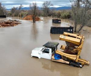 <i>En una vista aérea, se ve equipo agrícola sumergido en agua de inundación después de que el río Salinas se desbordara el 13 de enero de 2023 en Salinas, California. Varios eventos fluviales atmosféricos continúan golpeando California con precipitaciones récord y fuertes vientos. (Foto de JUSTIN SULLIVAN/GETTY IMAGES NORTH AMERICA/Getty Images vía AFP)</i>