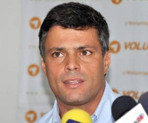 (FILES) In this file picture taken on February 18, 2014 Leopoldo Lopez (L), an ardent opponent of Venezuela's socialist government facing an arrest warrant after President Nicolas Maduro ordered his arrest on charges of homicide and inciting violence, receives a Christ necklace from his wife Lilian Tintori, during a demonstration before turning himself in to authorities, in Caracas. - Venezuelan opposition figure Leopoldo Lopez took refuge at the Chilean embassy in Caracas on April 30, 2019 with his family, Chile's foreign minister Roberto Ampuero said on Twitter. Lopez, a key opponent of President Nicolas Maduro, emerged earlier Tuesday from years of house arrest to join opposition leader Juan Guaido at a demonstration outside a military barracks. (Photo by Leo RAMIREZ / AFP)