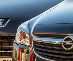 A picture taken on February 15, 2017 shows the logo of German car maker Opel (R) on a car next to a car with the logo of French car maker Peugeot, in Lille, northern France. French carmaker PSA said on February 14 it was thinking about taking over Opel and Vauxhall, loss-ridden European subsidiaries of US auto giant General Motors. PSA, which groups the Peugeot, Citroen and DS brands, 'is exploring the possibility of acquiring Opel and Vauxhall', a company spokesman told AFP. / AFP PHOTO / PHILIPPE HUGUEN