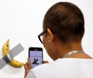 Una persona toma una fotografía de la obra ‘Comedian’, del artista italiano Maurizio Cattelan, durante el Art Basel en Miami, EE.UU., el 5 de diciembre de 2019. EFE/EPA/RHONA WISE