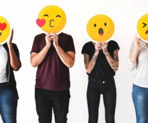 Diverse people holding emoticon