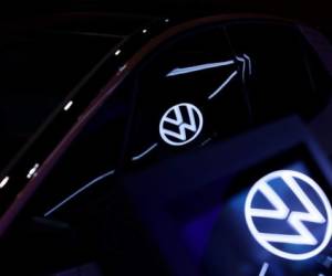 The VW Logo is reflected in a new Volkswagen (VW) ID.3 electric automobile at the headquarters of German car maker Volkswagen in Wolfsburg on October 26, 2020. (Photo by Ronny Hartmann / AFP)