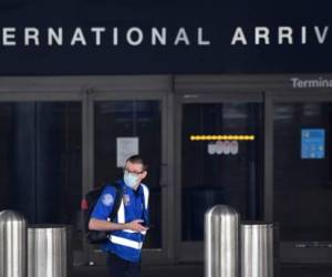 (ARCHIVOS) En esta foto de archivo, un agente de la TSA con una mascarilla en un aeropuerto internacional desierto de Los Ángeles en Los Ángeles, California, el 12 de mayo de 2020. - Además de requerir una prueba antes de volar, los viajeros a los EE. UU. Deberán ponerse en cuarentena A su llegada, el presidente de los Estados Unidos, Joe Biden, dijo el 21 de enero al anunciar una serie de medidas destinadas a contener la propagación del Covid-19. (Foto de Frederic J. BROWN / AFP)