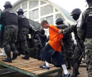 Policía Militar de Honduras escoltan a reos que son transferidos del Centro Penitencial en Tamara a El Pozo II, una prisión de mediana seguridad en El Paraiso. AFP PHOTO / Honduran Military Police