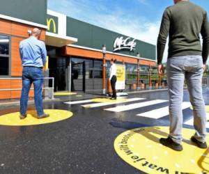 Customers wait outside on social distancing markings at a prototype location of fast food giant McDonald's for restaurants which respect the 1.5m social distancing measure, amid the coronavirus disease (COVID-19) outbreak, in Arnhem, Netherlands, May 1, 2020. REUTERS/Piroschka van de Wouw