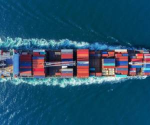 Aerial view Top speed with beautiful wave of container ship full load container with crane loading container for logistics import export or transportation concept background.