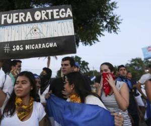 A woman holds a sign that reads in Spanish Ortega Out during a protest against the government of President Daniel Ortega in Managua Nicaragua Sunday April 11 2018 President Ortega has withdrawn changes to the social security system that touched off protests across the Central American nation that escalated into clashes with police leaving dozens dead AP Photo Alfredo Zuniga