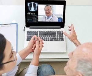 Senior man and his doctor having video conference with experienced medical worker