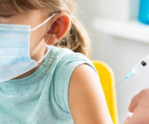 Little girl in the doctor's office is vaccinated. Syringe with vaccine against covid-19 coronavirus,flu,dangerous infectious diseases.Injection after clinical trials for human, child.Medicine concept.