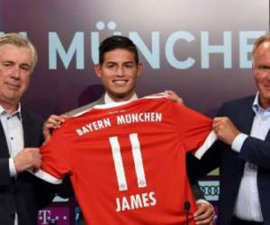 El mediocampista colombiano James Rodriguez (C) recibe su nueva camiseta del Bayern Munich, junto a Carlo Ancelotti (Izq.) y el CEO del club, Karl-Heinz Rummenigge (Der.) en la presentación oficial en Munich, al sur de Alemania. AFP PHOTO / Christof STACHE