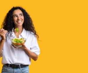 Cheerful Woman Eating Vegetable Salad From Bowl And Looking At Copy Space On Yellow Background, YoungLady Enjoying Heathy Nutrition And Organic Food, Having Vegetarian Meal For Lunch, Panorama
