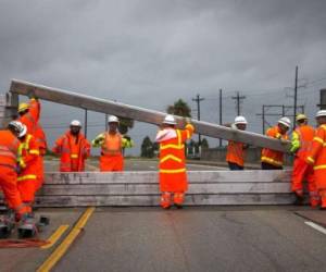 Trabajadores del Departamento de Transporte de Texas realizan obras en la autopista principal en Houston.