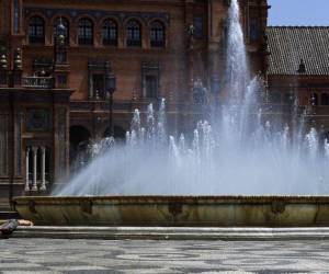 <i>Dos jóvenes sumergen la cabeza en el agua de una fuente para refrescarse, en la Plaza de España de Sevilla el 7 de agosto de 2023. España permanece en alerta máxima por el calor al enfrentarse a su tercera ola de calor del verano. Las regiones de Andalucía en el sur, el centro de Castilla-La Mancha y Extremadura en el oeste fueron colocadas en alerta naranja con temperaturas que se espera que alcancen los 43 grados centígrados (109 Fahrenheit) hoy, según la agencia meteorológica nacional Aemet.CRISTINA QUICLER / AFP</i>