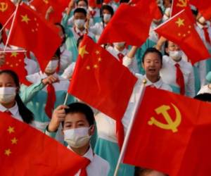 Performers wave national and party flags as they rehearse before the event marking the 100th founding anniversary of the Communist Party of China, on Tiananmen Square in Beijing, China July 1, 2021. REUTERS/Carlos Garcia Rawlins