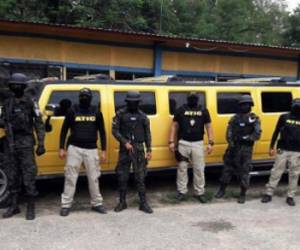 This handout photo released by the Technical Criminal Investigation Agency (ATIC) of Honduras shows members of that agency and military police guarding a limousine confiscated from druglords who replaced the leaders of the Los Cachiros cartel after they were extradited to the United States, in the city of Tocoa, department of Colon, to the northwest of Tegucigalpa, on June 21, 2017. In the 'Firestorm VI' operation, at least 24 properties were seized and arrest warrants were carried out against members of the 'Los Peludos' criminal organization. / AFP PHOTO / ATIC / HO / RESTRICTED TO EDITORIAL USE-MANDATORY CREDIT 'AFP PHOTO/AGENCIA TECNICA DE INVESTIGACION CRIMINAL DE HONDURAS' NO MARKETING NO ADVERTISING CAMPAIGNS-DISTRIBUTED AS A SERVICE TO CLIENTS-XGTY