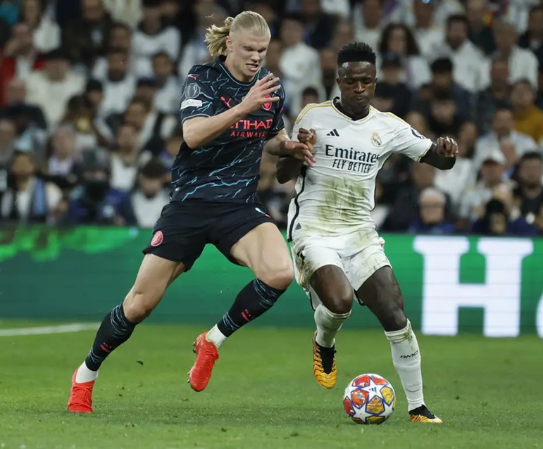 <i>Foto de archivo del delantero brasileño del Real Madrid, Vinicius Junior (d), que disputa el balón ante el delantero noruego del Manchester City, Erling Haaland. EFE / Juanjo Martín.</i>