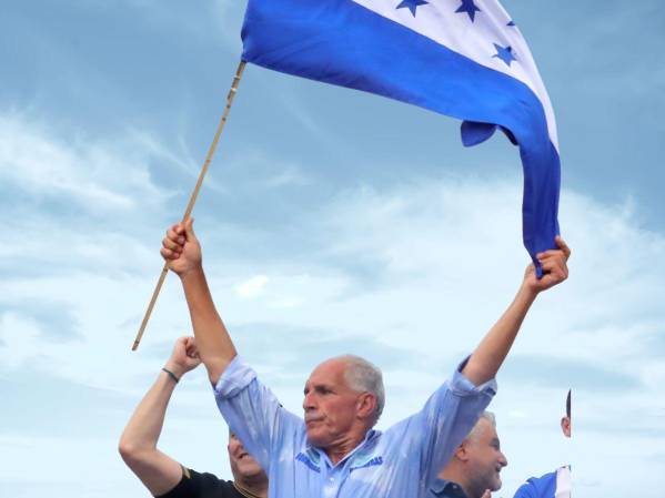 <i>Fotografía de archivo del 8 de noviembre de 2025 del entonces candidato a la Presidencia de Honduras, Nasry Asfura, sosteniendo una bandera durante un evento, en Tegucigalpa (Honduras). Conocido como 'Papi a la orden' por su trato directo y su discurso centrado en el trabajo, el conservador Nasry 'Tito' Asfura se convirtió este miércoles en el virtual presidente electo de Honduras, tras una trayectoria marcada por dos intentos fallidos y el respaldo público del presidente de EE.UU., Donald Trump, a su candidatura. EFE/ Gustavo Amador/ ARCHIVO</i>