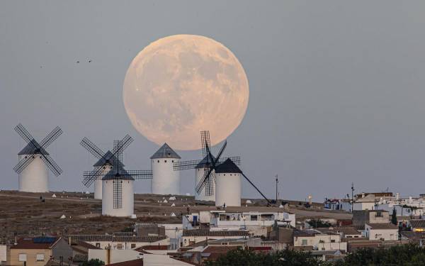 <i>Llega la luna llena de octubre, la primera del otoño, conocida como Luna de la cosecha y que ademas coincide con la primera superluna del año 2025. En la imagen, la luna entre los molinos de Campo de Criptana, en Ciudad Real. EFE/Javier Belver</i>
