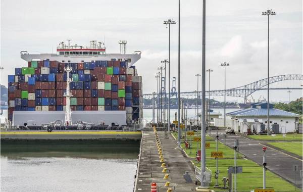 <i>Un carguero navega por el Canal de Panamá en el área de las Esclusas de Cocolí, en la Ciudad de Panamá, el 25 de agosto de 2023. El Canal de Panamá, afectado por la sequía, mantendrá restricciones al paso de barcos durante un año. FOOTO IVÁN PISARENKO / AFP</i>