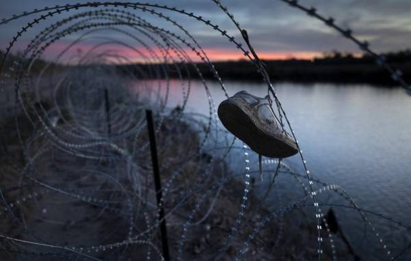 <i>El zapato de un niño cuelga atrapado en alambre de púas en la cima de la orilla del Río Grande el 9 de enero de 2024 en Eagle Pass, Texas. FOTO John Moore/Getty Images/AFP</i>