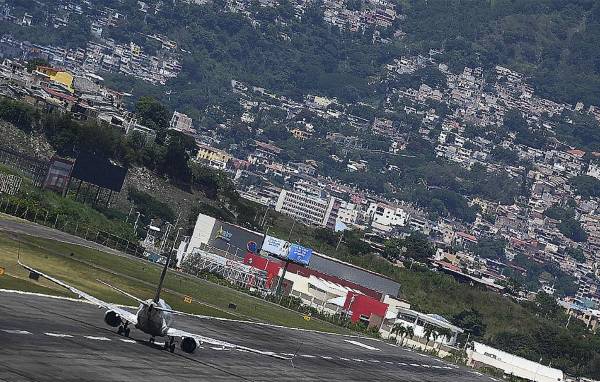 <i>Un avión de American Airlines despega del Aeropuerto Internacional Toncontín, en Tegucigalpa, el 15 de octubre de 2021. Es considerado uno de los más peligrosos del mundo. FOTO ARCHIVO AFP</i>