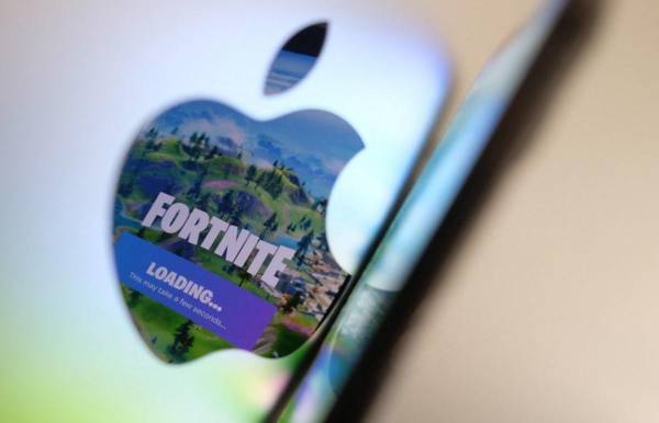 <i>Esta fotografía ilustrativa muestra la pantalla inicial de Fortnite de Epic Games reflejándose en el logotipo de Apple en la parte trasera de un I-mac. FOTO Chris DELMAS/AFP</i>